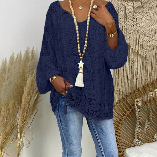 Woman in blue lace blouse and jeans with accessories.