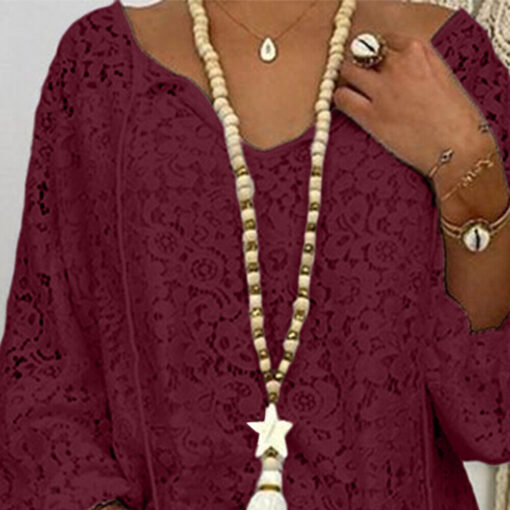 Woman wearing maroon lace blouse, necklace, and accessories.