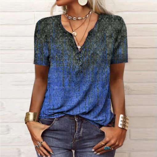 Woman in patterned blue top and jeans with accessories.