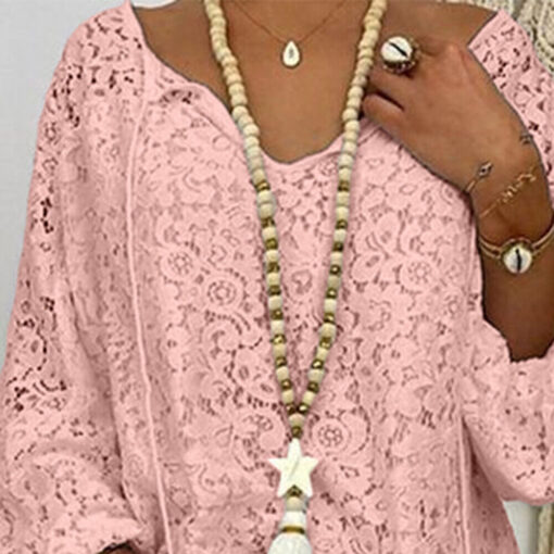 Person wearing pink lace top and beaded necklace.