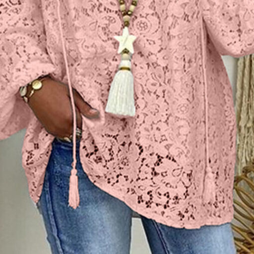 Woman in pink lace top and denim.