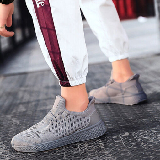 Person wearing grey sneakers and white joggers.