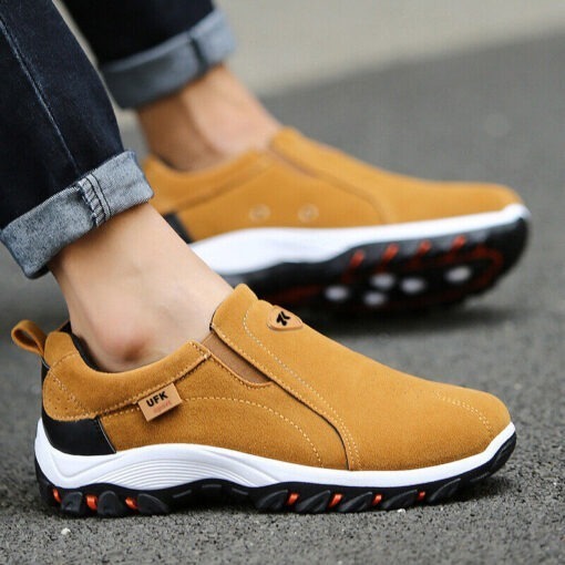 Person wearing modern brown slip-on sneakers.