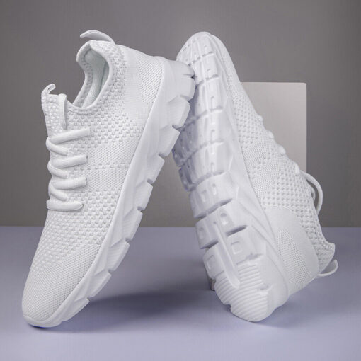 White modern running sneakers on gray background.