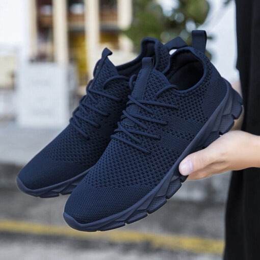 Black athletic sneakers on urban background.