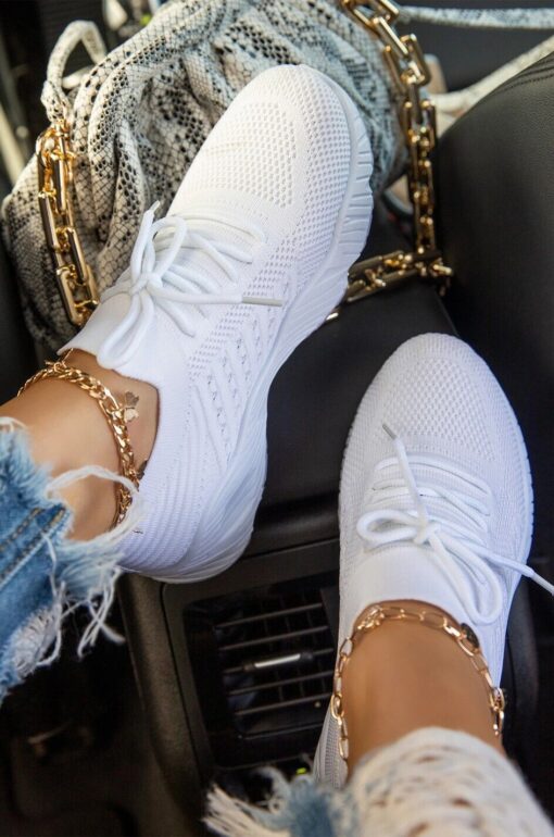 White sneakers and gold anklet in car setting.