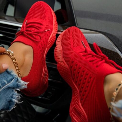 Red athletic sneakers in car setting.