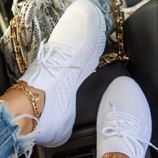 White sneakers, gold bracelet, jeans, car interior.