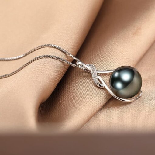 Elegant pearl pendant on silky fabric background.