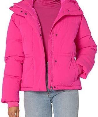 Woman wearing a pink puffer jacket and jeans.