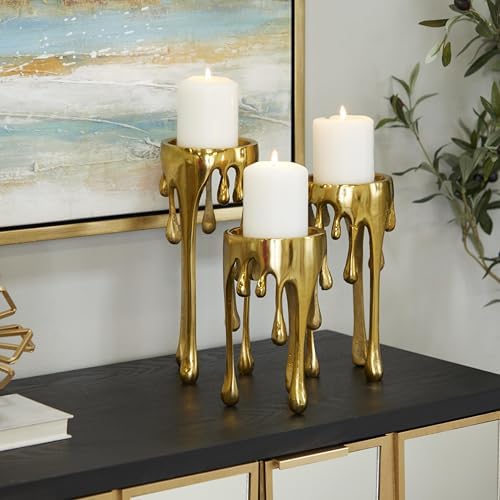 Gold candle holders with white candles, modern decor.